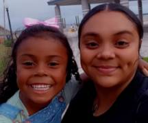 A mother and daughter smiling