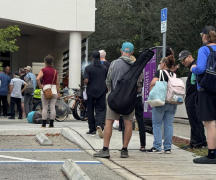A group of people standing in line to receive a hot holiday meal