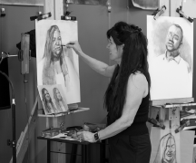 An artist drawing charcoal portraits