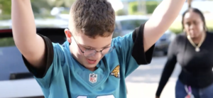 13-year-old boy raising his arms in celebration