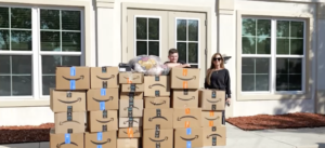 Woman and teenage boy standing behind many boxes of donated items