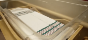 Empty newborn hospital bassinet with a blanket inside