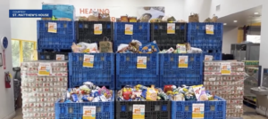 Stacks of large food drive crates overflowing with donated food at St. Matthew's House
