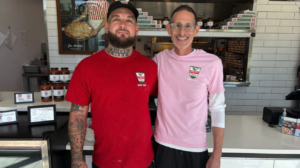 A graduate of the St. Matthew’s House Vocational Training Program standing with Aurelio’s Pizza franchise owner